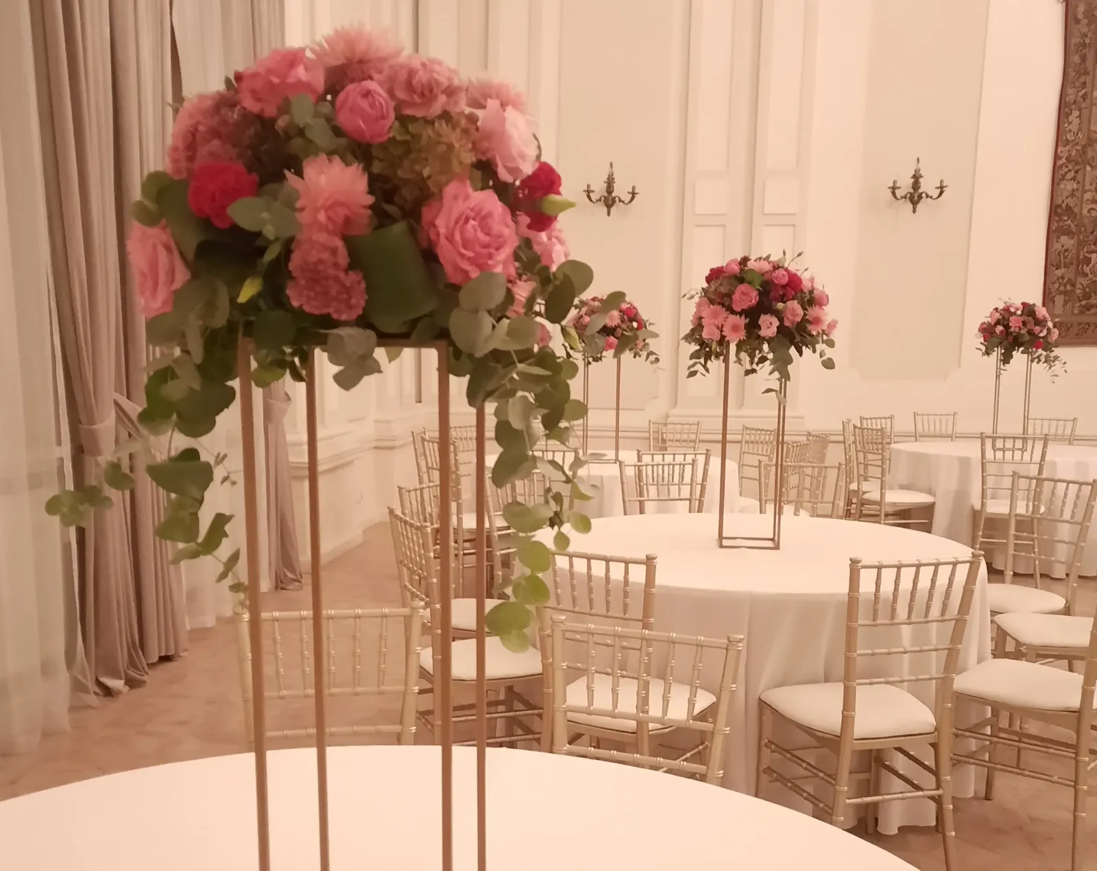 Dekoracja sali z różowymi kulami kwiatowymi na stojakach - Wiosenna Pracownia Florystyczna, Kraków